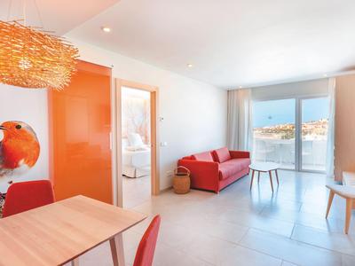 Bright living room with red sofa, large window, and modern dining area.