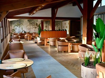 Ristorante dell'hotel luminoso e accogliente con mobili in legno e grandi finestre