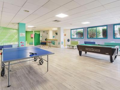 Bright recreation room with ping pong table and pool table in a hotel