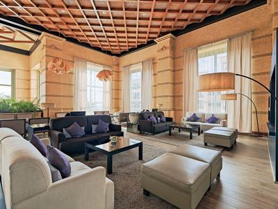 Elegancki salon hotelowy z wygodnymi sofami, stylowymi fotelami i dużymi oknami.