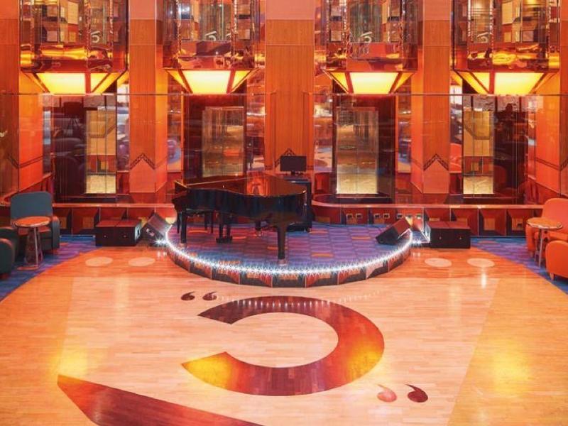 Luxurious hotel lobby with circular seating, polished floors, and warm amber lighting.