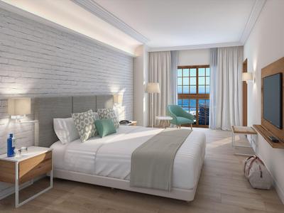 Chambre d'hôtel moderne avec lit double, fenêtre vue mer et décoration minimaliste.