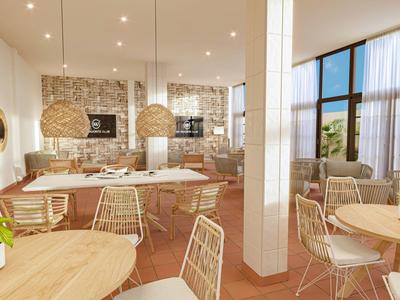 Bright dining area with modern wood and metal chairs, round tables, and large windows.