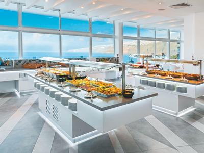 Modernes Buffet mit Blick auf das Meer und große Fenster in einem hellen Restaurant.