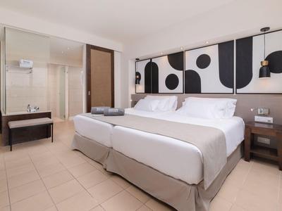 Modernes Hotelzimmer mit zwei Einzelbetten, stilvoller Wandkunst und minimalistischer Einrichtung.