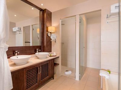 Moderne badkamer met dubbele wastafels, houten kast en inloopdouche