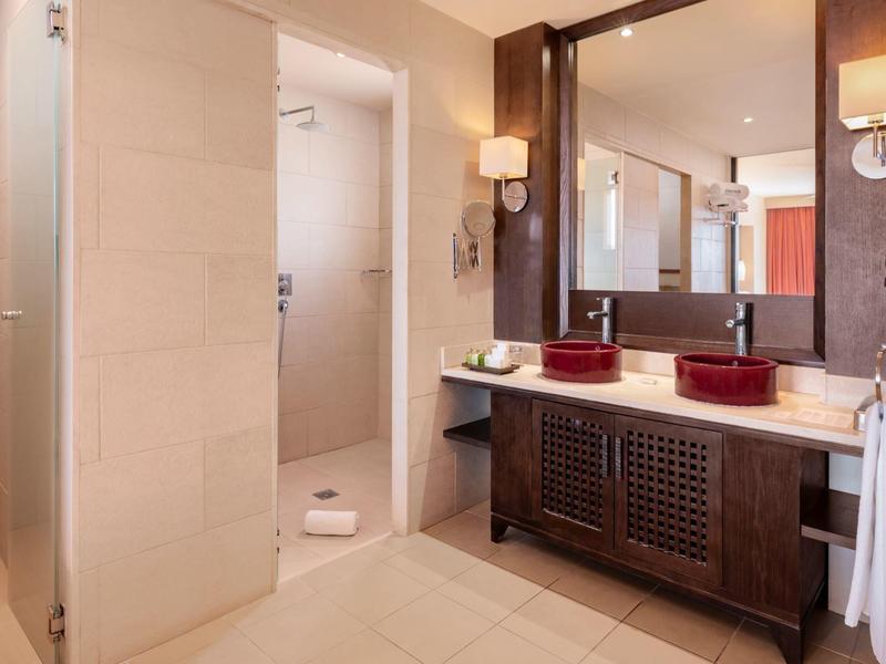 Moderne badkamer met dubbele wastafel, houten meubel en inloopdouche.