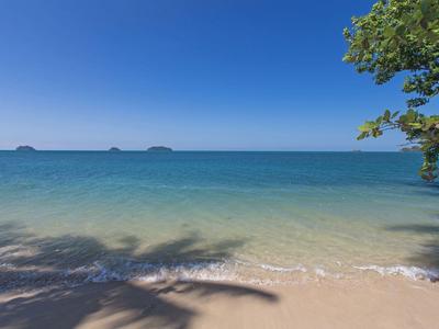 Klares Meer mit sanften Wellen und einigen Inseln am Horizont bei strahlend blauem Himmel