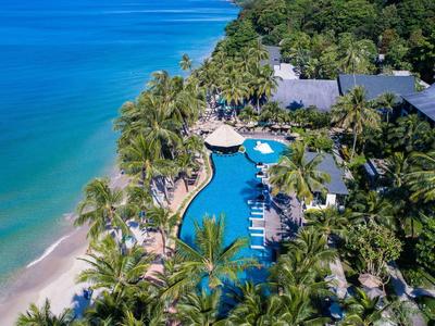 Blick auf einen tropischen Resort-Pool am Strand mit Palmen und Sitzbereichen