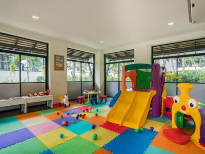 Heller Spielraum mit buntem Teppich, Rutsche und Spielzeug für Kinder.