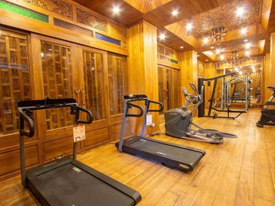 Gym room with several treadmills and exercise equipment in a bright wood-paneled space