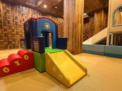 Colorful indoor children's play area with climbing and sliding modules on a light floor.