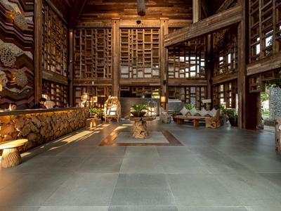 Großer Hotel-Loungebereich mit Holzakzenten, bequemen Sesseln und warmem Licht.