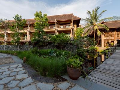 Ein Holzresort mit einem Steg und üppiger grüner Vegetation bei bewölktem Himmel.