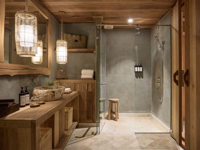 Rustikales Badezimmer mit Holzvertäfelung, großer Dusche und hölzernen Möbeln.