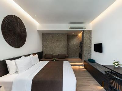 Modernes Hotelzimmer mit großem Bett, wandmontiertem Fernseher und stilvoller Beleuchtung.