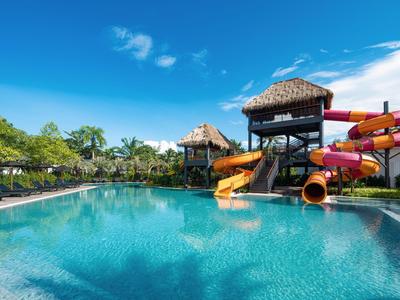 Großer Pool mit bunten Wasserrutschen unter klarem blauem Himmel