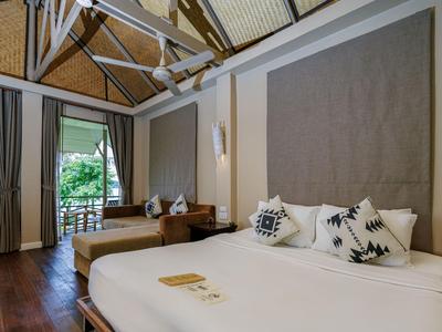 Modernes Hotelzimmer mit zwei Betten, großen Fenstern und Holzböden, helle und ruhige Atmosphäre.