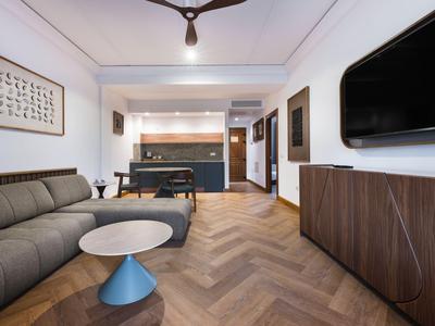 Área de lounge de hotel moderna con sofá, mesa, televisor y futbolín.