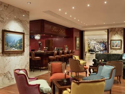 Elegantes Restaurant mit farbigen Sesseln, Marmorwänden und stimmungsvoller Beleuchtung.