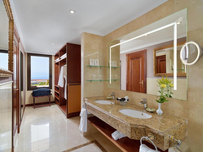 Bagno moderno dell'hotel con grande specchio illuminato e vista attraverso le finestre.