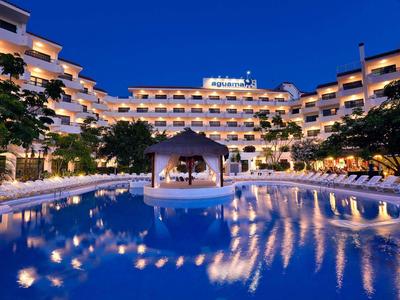 Hotel illuminato con ampia piscina riflettente di notte