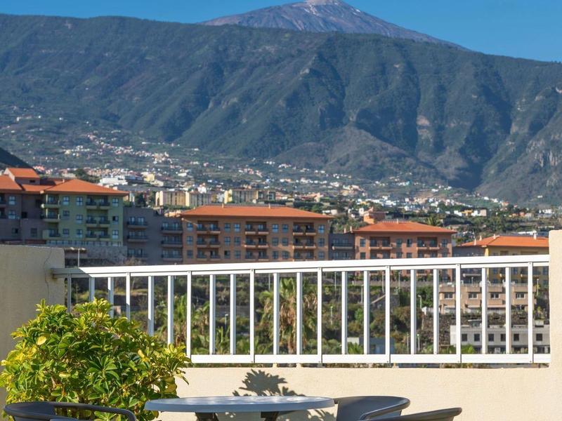 Terrazza con tavolo e sedie davanti a panorama montano e cielo sereno