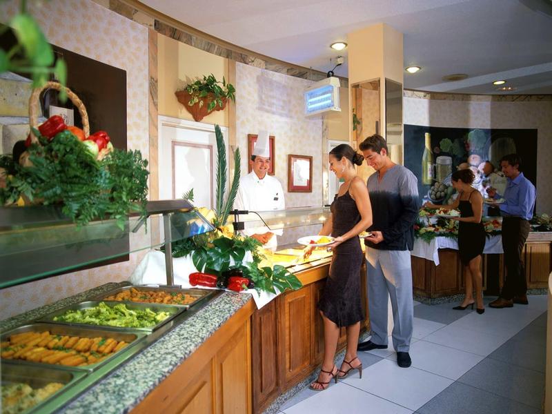 People selecting food at a buffet in a restaurant or hotel.