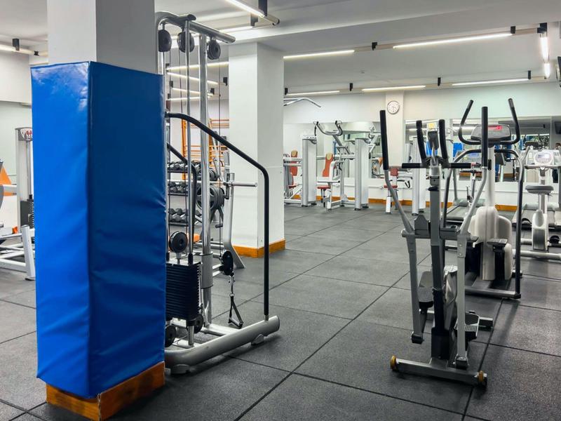 Modern gym with exercise machines and padded blue pillar protector