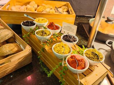 Große Auswahl an verschiedenen Broten und Aufstrichen auf einem Buffet in Holzkisten.
