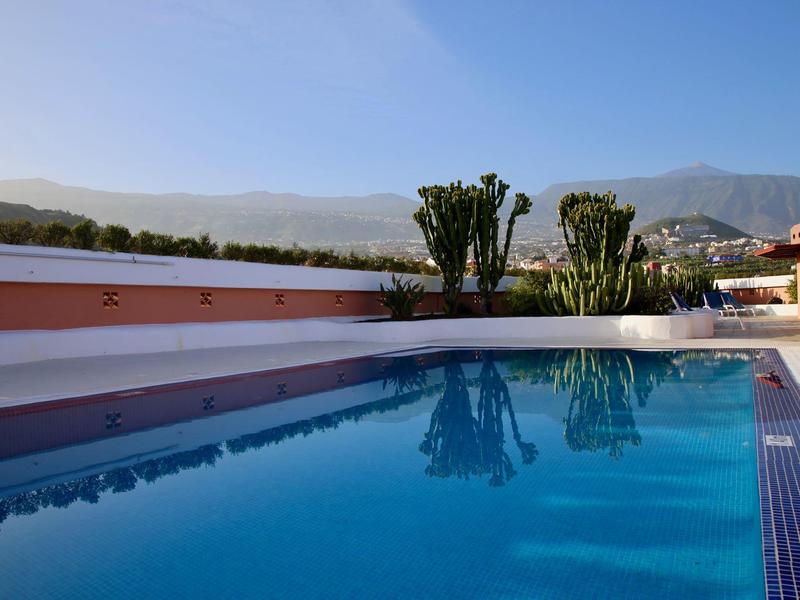 Acqua limpida e blu in una piscina con vista sulle montagne e il cielo azzurro.