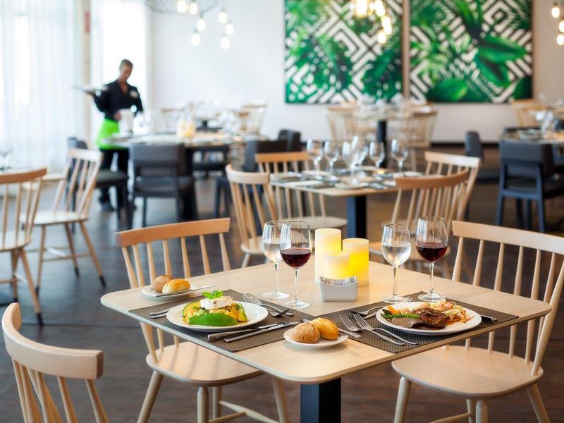 Stůl v restauraci elegantně prostřený s jídlem a nápoji v moderním prostředí.