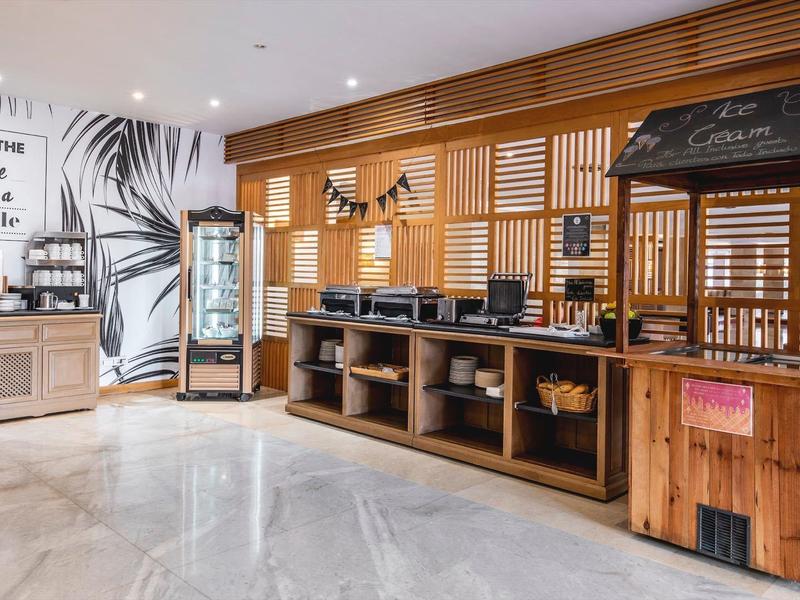 Moderna zona de hotel con gran buffet gastronómico y revestimientos de madera.