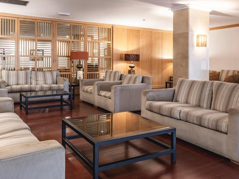 Amplia sala de estar acogedora con varios sofás, mesas bajas y decoración cálida de madera.