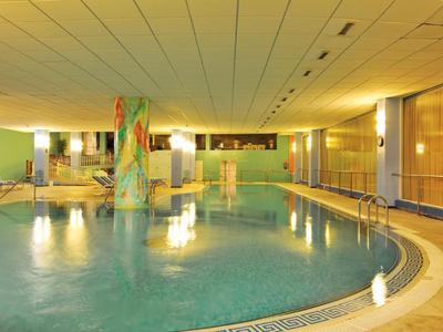 Beheiztes Hallenbad in einem Hotel mit Säulen und sanfter Beleuchtung.