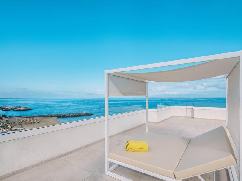 Moderne open strandcabana met uitzicht op zee en heldere blauwe lucht.