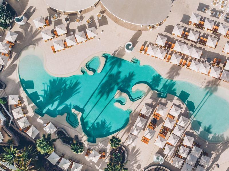 Luxe zwembadgebied met parasols en ligbedden, luchtfoto