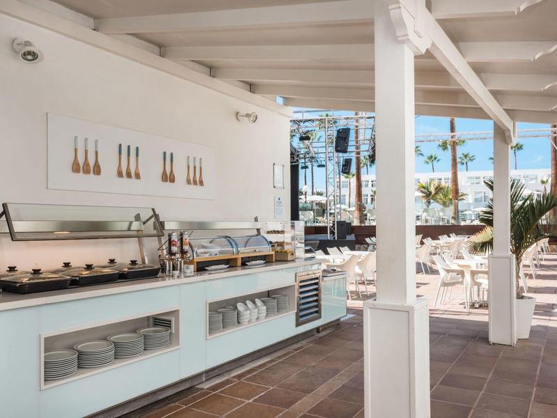 Cocina al aire libre moderna con estación de buffet bajo área techada en entorno hotelero