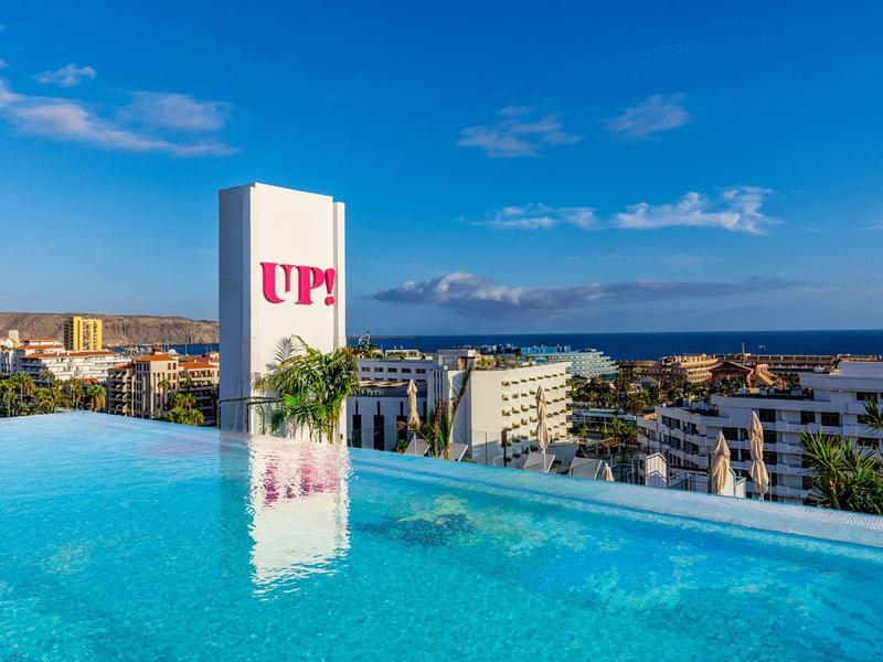 Infinity bazén na střešní terase s výhledem na pobřežní město a moře