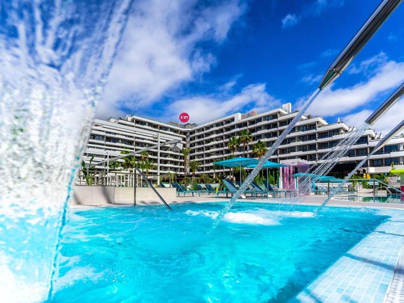 Moderní hotel s průzračným venkovním bazénem pod modrou oblohou