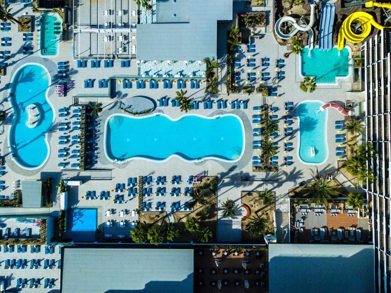 Letecký pohled na hotelový bazén s několika bazény a lehátky