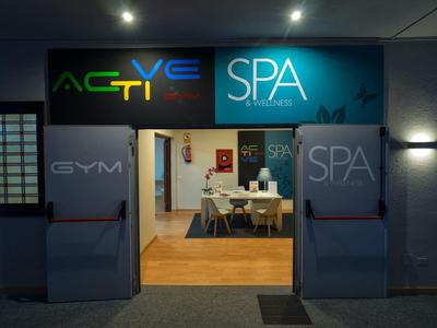 Entrada a la zona de gimnasio y spa con señalización moderna y interior luminoso.