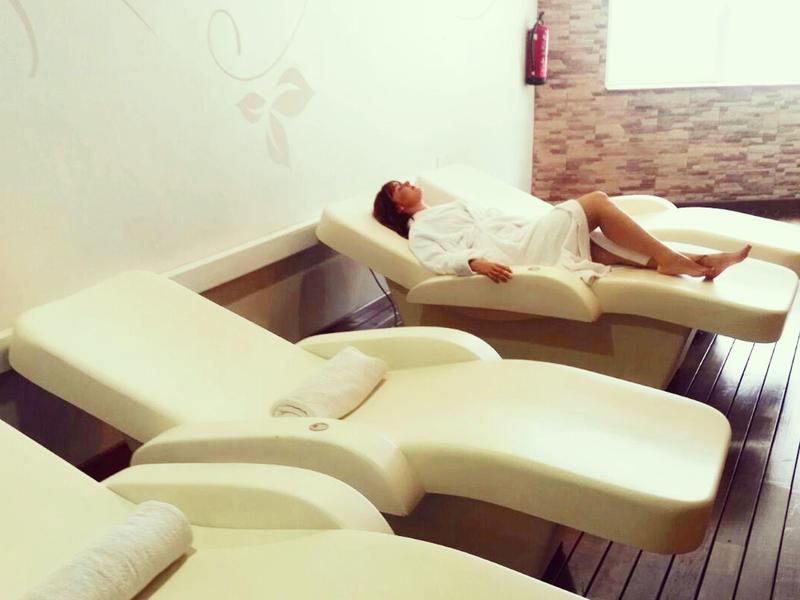 Sala con tres tumbonas elegantes, una usada para un tratamiento.