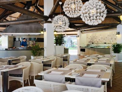 Modern eingerichteter Innenraum eines Restaurants mit Holzbalken und eleganten Lampen.