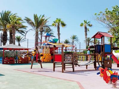 Aire de jeux colorée avec toboggans et structures d'escalade près des palmiers par une journée ensoleillée.