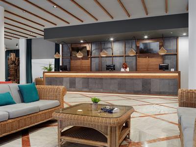 Reception moderna con arredi in vimini e atmosfera accogliente.