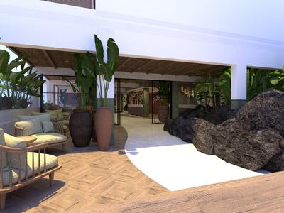 Nowoczesny teren na zewnątrz z meblami do wypoczynku, roślinami i kamiennym murem w hotelu.