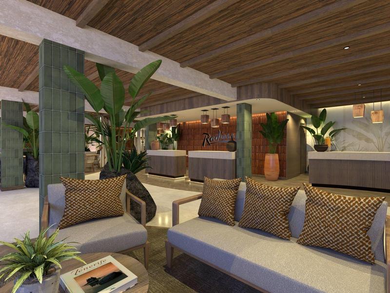 Przytulny salon hotelowy z nowoczesnymi sofami, roślinami i ciepłym, drewnianym wystrojem.