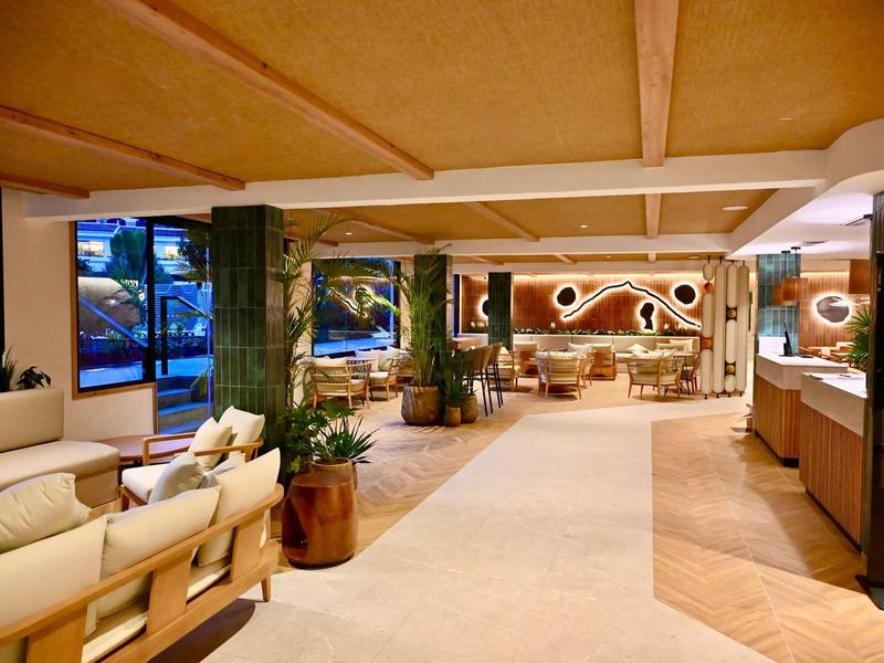 Jasny hol hotelowy z sofami, roślinami i nowoczesnym wystrojem w świetle dziennym.