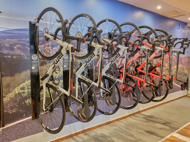 Varias bicicletas colgadas en un rack de pared en el sótano o sala de almacenamiento de un hotel.